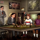 A still from the season 12 trailer for Archer features Cyril standing while Archer plays a tabletop game with two nerds.